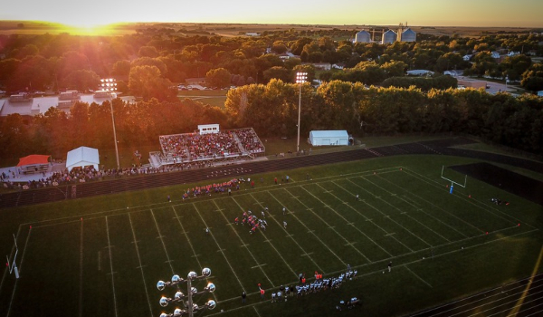 A high school football game at sunset.