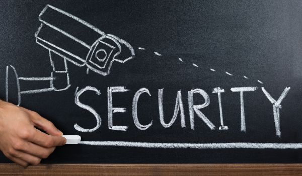 Security camera drawn in chalk on a blackboard