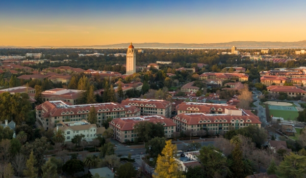 Aerial view of Stanford University campus showcasing the iconic Hoover Tower and surrounding buildings at sunset