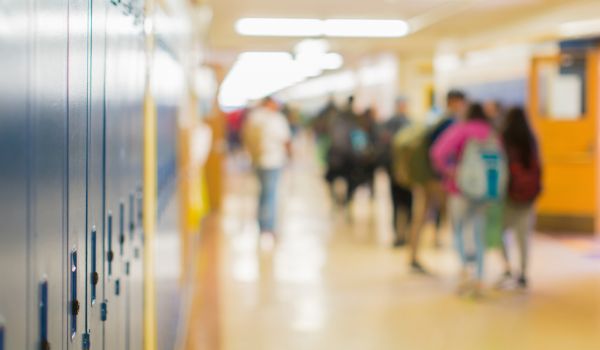 Blurred image of high school hallway with students moving around