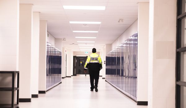 Security guard patrolling school hallway
