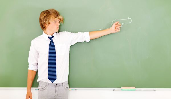 Student next to drawing of gun