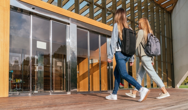Two college classmates entering the university