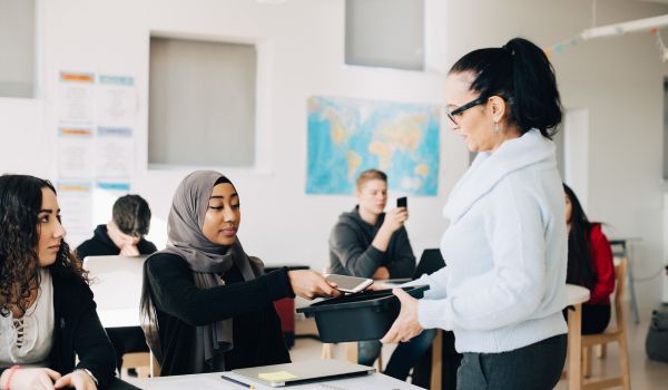 Teacher confiscating smart phones from students in lecture hall at university
