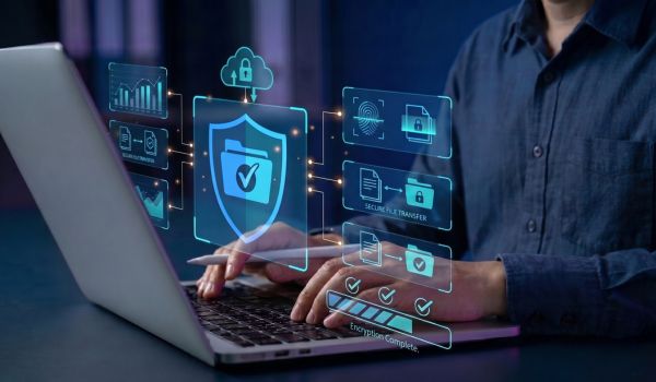 Person using a laptop with data security icons.