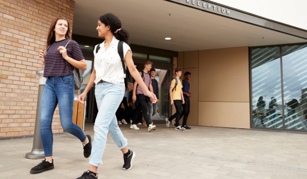 Group Of High School Students Walking Out Of College Building Together